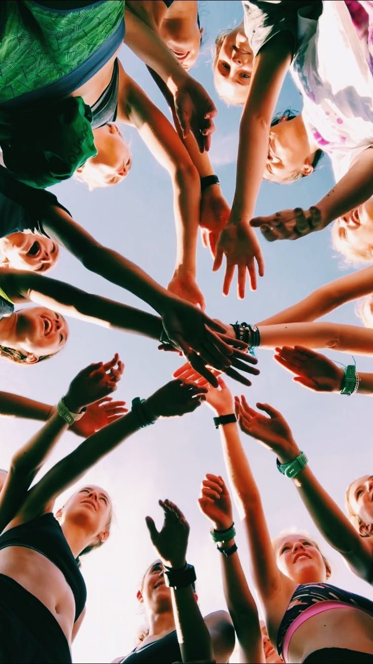Several people's hands joined together in a circle, seen from above.
